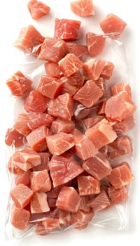 Fresh raw pork meat cubes in plastic packaging, isolated on a white background.