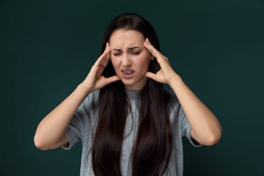 A woman is shown holding her head with both hands, displaying signs of distress or overwhelming emotion. Her facial expression conveys inner turmoil or a moment of intense stress.