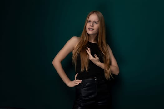 A woman in a stylish black dress strikes a pose for a photograph, showcasing her confidence and elegance. Her posture exudes poise and sophistication, making for a striking visual moment.