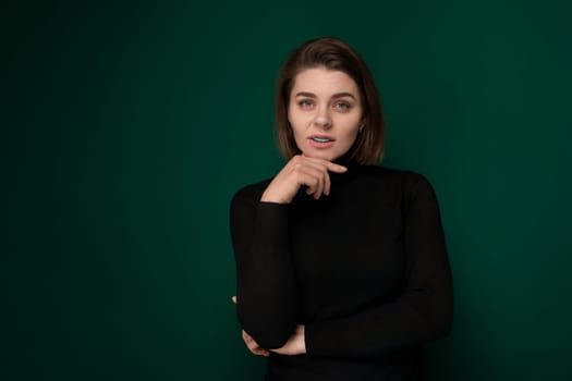 A woman wearing a black shirt is striking a pose for a photograph. She appears confident and stylish as she poses in front of the camera, showcasing her sense of fashion.