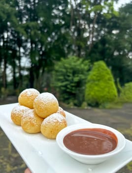 Homemade delicious sweet Dutch poffertjes mini pancakes with icing powdered sugar and chocolate fillings with additional chocolate sauce for cooking multimedia content creation