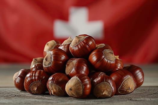 A bunch of chestnuts on wood against the background of the Swiss flag.