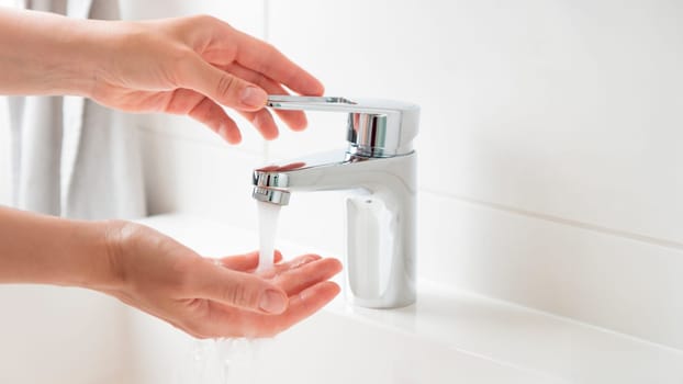 Banner of woman is opening and closing water flow tap and filling water temperature. Water running from chrome faucet. Bathroom plumbing. Using water resources concept