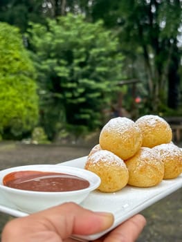 Homemade delicious sweet Dutch poffertjes mini pancakes with icing powdered sugar and chocolate fillings with additional chocolate sauce for cooking multimedia content creation