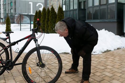 European elderly man rents a bicycle to ride around the city.