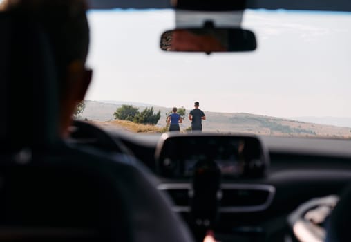 A romantic couple is captured running outdoors from the perspective of a car, embodying adventure and togetherness in their journey