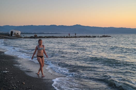 girl walking along the beach at sunset 2