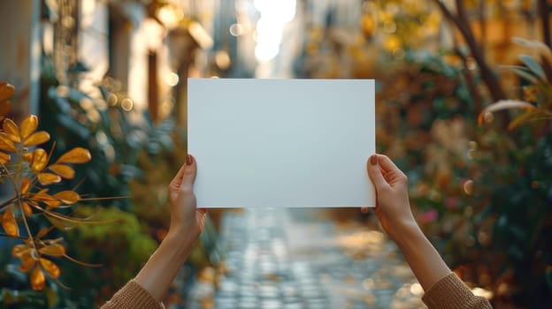 A person holds a white piece of paper in their hands with space for promotional text.