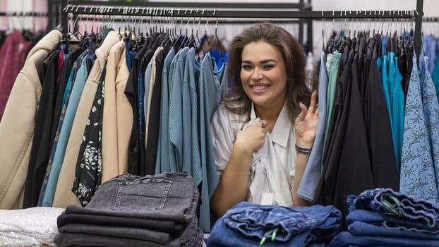 A fat woman in a plus size store peeks out from behind racks of clothes