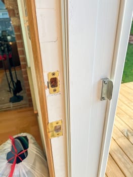 Denver, Colorado, USA-November 25, 2023-Detailed view of a door frame with lock hardware removed, showing the doors edge and lock cutouts. The photo captures the preparation phase for installing a new door lock or handle.