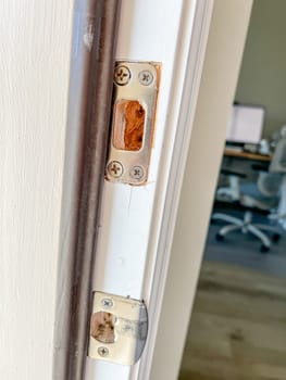 Denver, Colorado, USA-November 25, 2023-Detailed view of a door frame with lock hardware removed, showing the doors edge and lock cutouts. The photo captures the preparation phase for installing a new door lock or handle.