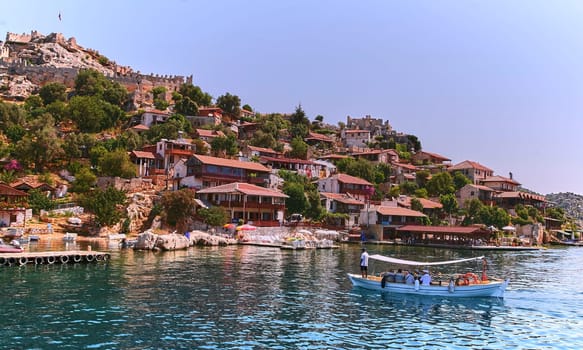 Experience the charm of traditional Turkish architecture as you cruise along serene waters, admiring quaint houses against a picturesque landscape, capturing the essence of this historic heritage.
