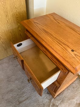 Denver, Colorado, USA-October 28, 2023-A detailed view of an open wooden dresser drawer, showcasing its smooth wooden interior and red velvet-lined compartments. The craftsmanship and elegant design make it a perfect storage solution for precious items.