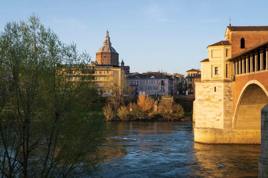 Nice view of Ponte Coperto (covered bridge) and Duomo di Pavia (Pavia Cathedral) in Pavia at sunny day, Lombardy, italy.