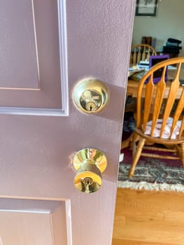 Denver, Colorado, USA-November 25, 2023-A close-up view of a polished brass door handle and matching deadbolt on a wooden door. The shiny brass fixtures add a touch of elegance and security to the doors natural wood grain.