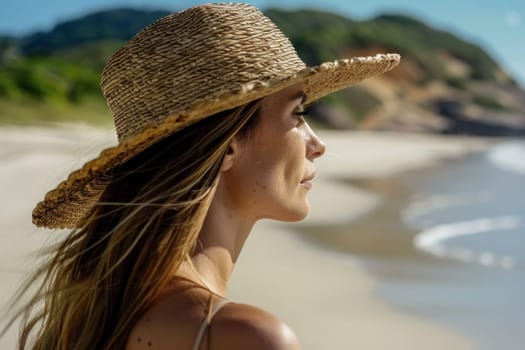 Woman in straw hat enjoying serene beach view with ocean in the background on vacation trip
