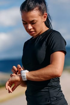 A close up shot captures a woman closely examining fitness analytics on her smartwatch display, reflecting on her post run performance with technological precision