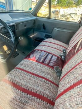 Denver, Colorado, USA-September 18, 2023-Close-up view of the interior of a 1985 Ford truck, showcasing the classic dashboard and vintage seat upholstery. The image captures the nostalgic essence of this well-preserved vehicle, highlighting its manual transmission and retro design elements.