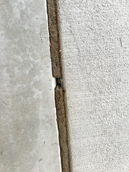 A close-up view of a repaired concrete corner where a driveway meets a wall. The image highlights the maintenance work done to seal and fix the joints, ensuring stability and durability.