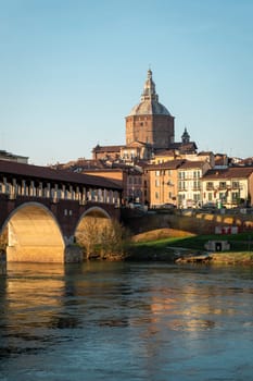 Nice view of Ponte Coperto (covered bridge) and Duomo di Pavia (Pavia Cathedral) in Pavia at sunny day, Lombardy, italy.