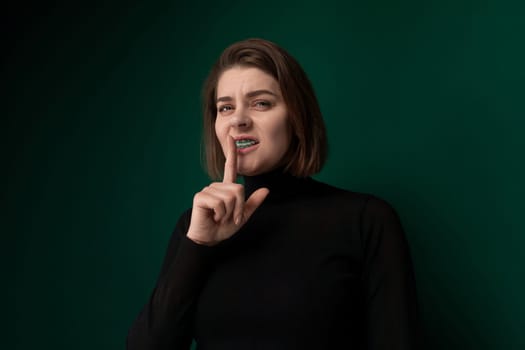 A woman holding a toothbrush in her mouth, scrubbing her teeth with deliberate motions.