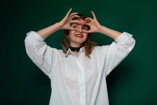 A woman standing with her hands raised up to her eyes, covering them partially or fully. She appears to be shielding her eyes or adjusting her vision.