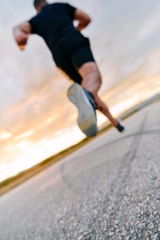 A breathtaking wide shot captures a determined man gracefully running against the backdrop of a vibrant sunset