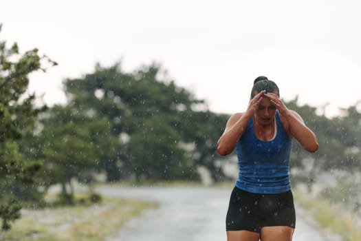 Rain or shine, a dedicated woman powers through her training run, her eyes set on the finish line.