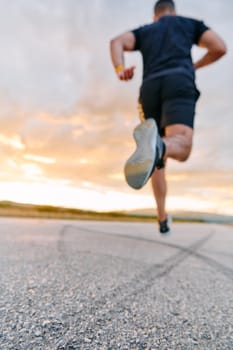 A breathtaking wide shot captures a determined man gracefully running against the backdrop of a vibrant sunset