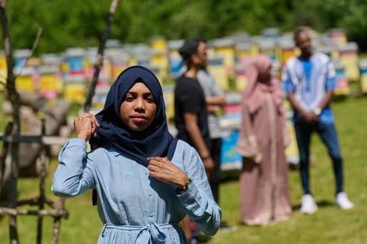 African American Muslim woman in hijab explores natural bee farms for honey production, blending tradition with sustainability in the serene countryside.