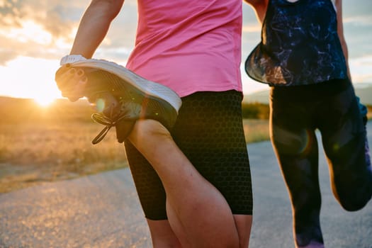 Womens athletes are seen stretching after an intense run, epitomizing dedication to fitness and appreciation for nature's beauty.