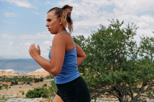 A determined female athlete runs through a forest trail at sunrise, surrounded by breathtaking natural beauty and vibrant greenery.