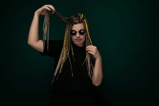 A woman with dreadlocks styled in a black shirt poses for the camera, showcasing her unique hairstyle and fashion sense.