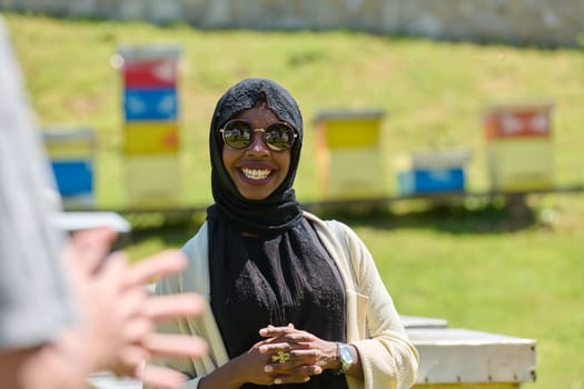 African American Muslim woman in hijab explores natural bee farms for honey production, blending tradition with sustainability in the serene countryside.