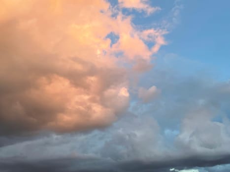Sunset clouds in the sky. Natural texture and background. Dramatic sunset. Red-orange clouds against the blue sky. Sunset orange red yellow pink clouds against blue sky texture. High quality photo