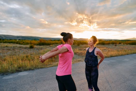 Two women athletes are seen stretching after an intense run, epitomizing dedication to fitness and appreciation for nature's beauty.