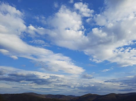 Beauty cloud against a blue sky background. Sky slouds. Blue sky with cloudy weather, nature cloud. White clouds, blue sky and sun. High quality photo