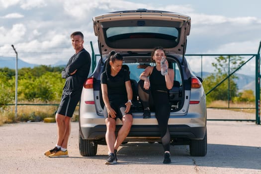 A unified team of athletes stands ready next to a car, symbolizing camaraderie and preparation for the challenges ahead.