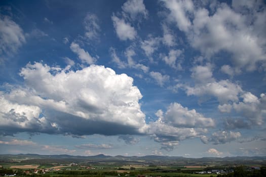 Beauty cloud against a blue sky background. Sky slouds. Blue sky with cloudy weather, nature cloud over the landskape. Over the land white clouds, blue sky and sun. High quality photo