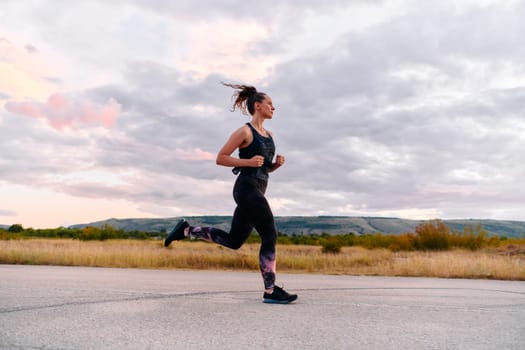 A determined athlete runs confidently under the sun, surrounded by stunning natural scenery, showcasing strength and resilience in her pursuit of fitness