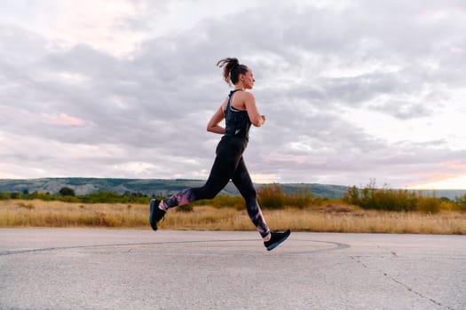 A determined athlete runs confidently under the sun, surrounded by stunning natural scenery, showcasing strength and resilience in her pursuit of fitness