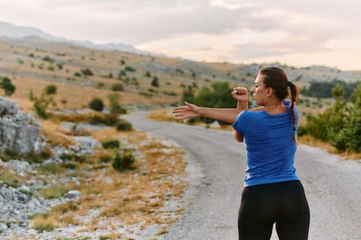 A determined female athlete stretches her muscles after a strenuous run through rugged mountain terrain, surrounded by breathtaking rocky landscapes.