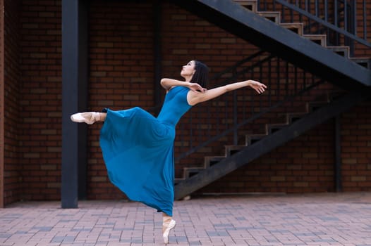 Beautiful Asian ballerina dancing outdoors. Urban landscape