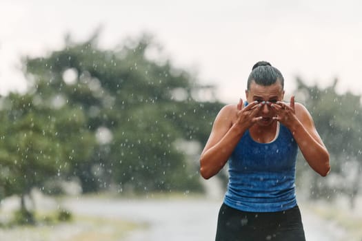 Rain or shine, a dedicated woman powers through her training run, her eyes set on the finish line.