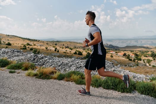 A muscular male athlete runs along a rugged mountain path at sunrise, surrounded by breathtaking rocky landscapes and natural beauty.