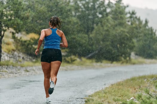 Rain or shine, a dedicated woman powers through her training run, her eyes set on the finish line.