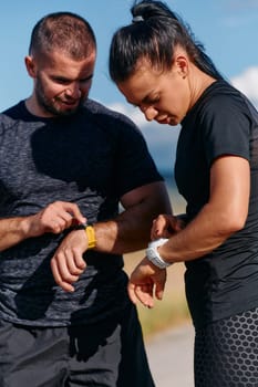 A couple checks their running results together on a smartwatch, sharing the joy of progress and fitness achievement after their run.