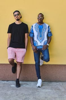 A depiction of camaraderie and cultural diversity two male friends, one an African American teenager dressed in Sudanese traditional attire, leaning against a vibrant yellow wall