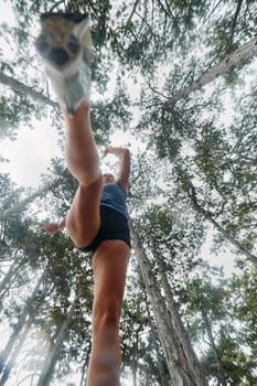 A brave woman traverses through the forest, fearlessly leaping over dangerous obstacles with determination and agility, showcasing her adventurous spirit and athletic prowess.