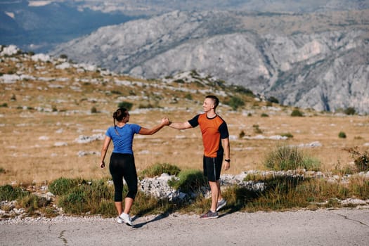 A jubilant couple celebrates their triumphant finish after a challenging morning run, exuding happiness and unity amidst the refreshing outdoor scenery.